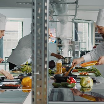 In der Küche herrscht geschäftiges Treiben, während Köche mit frischen Zutaten und verschiedenen Kochtechniken köstliche Speisen kreieren.