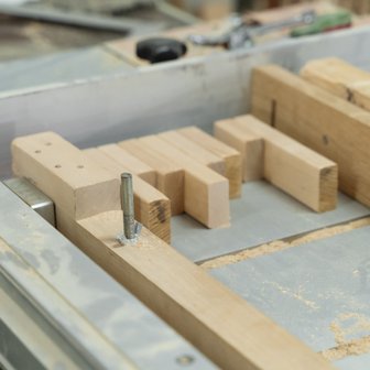 Ein Blick auf eine Holzwerkstatt, in der mehrere Holzblöcke auf einer Arbeitsfläche für die Bearbeitung vorbereitet sind.